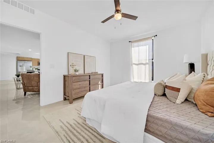 Bedroom featuring stainless steel fridge with ice dispenser, visible vents, ceiling fan, and recessed lighting
