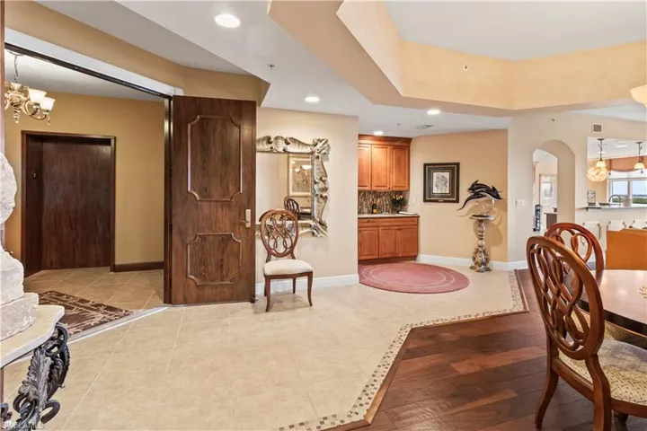 Dining room with a chandelier, recessed lighting, light tile patterned floors, and arched walkways