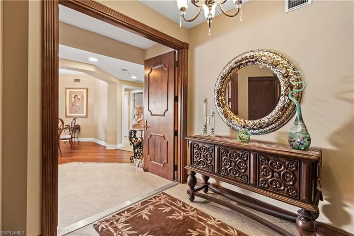 Hallway with tile patterned flooring, a chandelier, and recessed lighting
