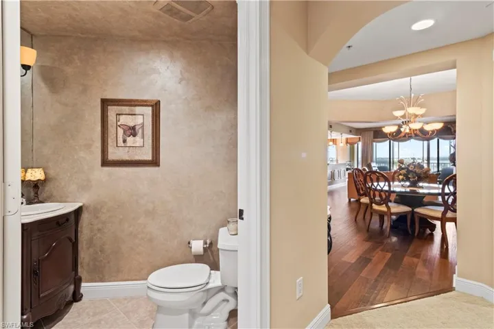 Half Bathroom featuring vanity, a chandelier, and wood finished floors