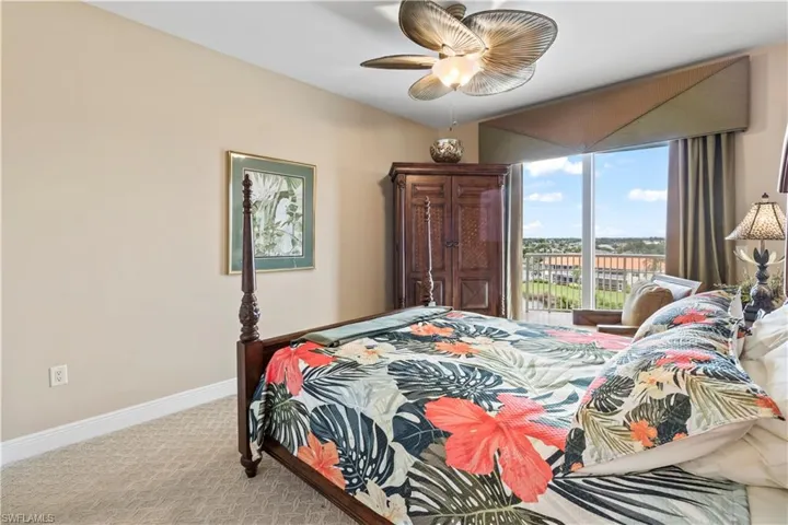 Bedroom #2 with carpet floors and a ceiling fan with sliders out to street side balcony