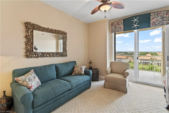 Carpeted Den room with ceiling fan and sliders to street side balcony