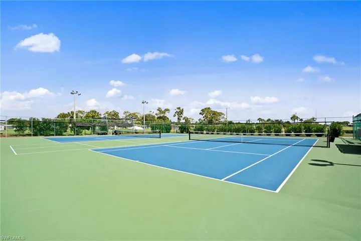 View of tennis court with fence and community basketball court
