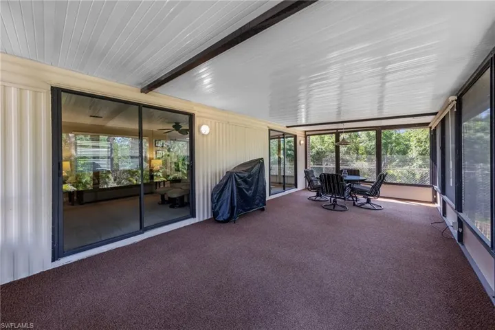 Unfurnished sunroom featuring beamed ceiling