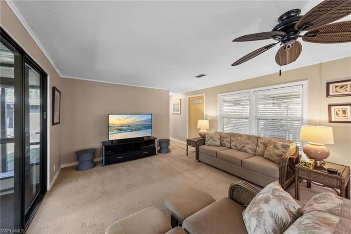 Living room featuring ceiling fan, baseboards, visible vents, and carpet floors