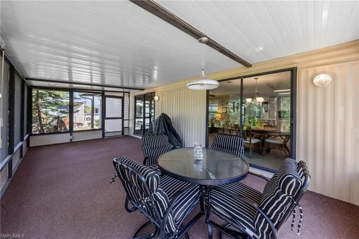 Sunroom / solarium with outdoor dining space, carpet, and plenty of natural light