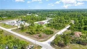 Expansive lot featuring a paved road frontage, surrounded by mature trees and natural landscaping