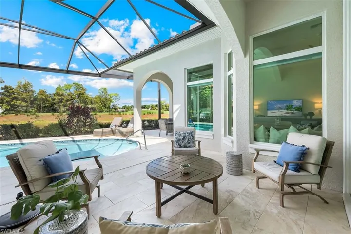Outdoor pool with a sunroom, a lanai, a patio area, and an outdoor hangout area