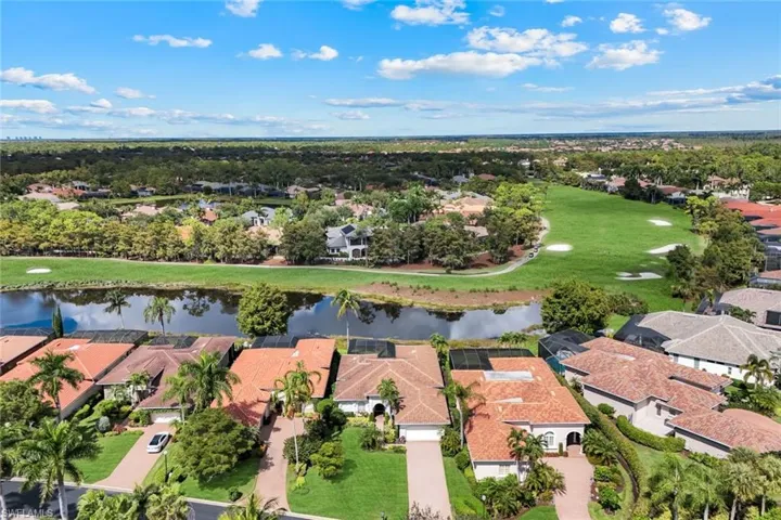 Aerial view of residential area with a large body of water and a golf course