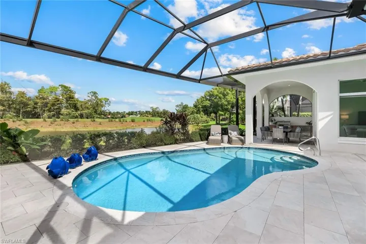 Swimming pool with a lanai, a water view, a patio, and a sunroom