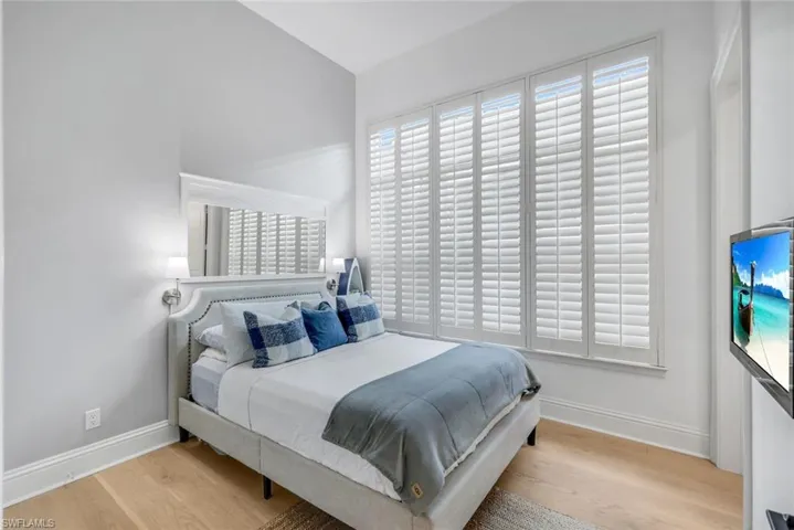 Bedroom featuring light wood-style flooring and vaulted ceiling