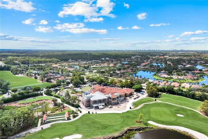 Aerial view of property's location with a golf club, a large body of water, and nearby suburban area