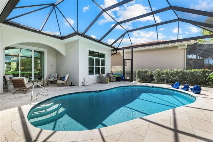 Outdoor pool with a sunroom, a patio area, and a lanai