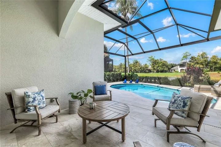 Swimming pool featuring a sunroom, a lanai, a patio area, and a water view