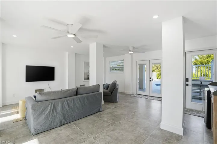 Living room with french doors, recessed lighting, and a ceiling fan Virtually Edited