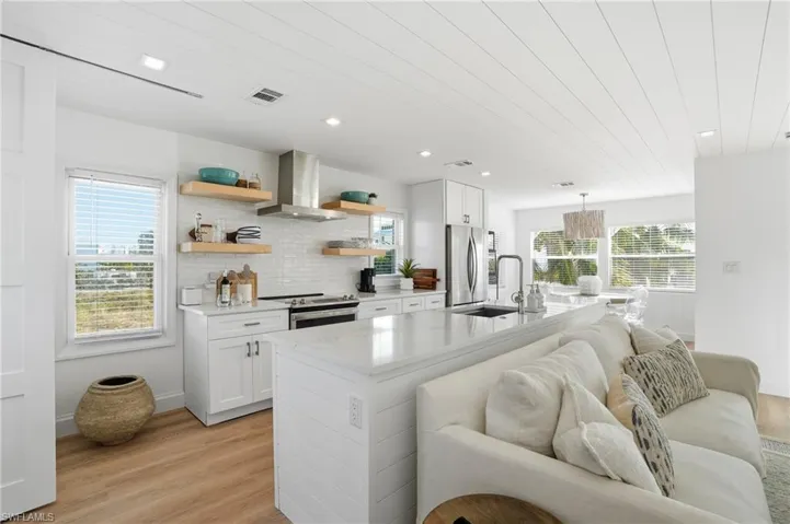 Kitchen featuring light stone countertops, white cabinets, light wood-style floors, open shelves, and wood ceiling Virtually Edited
