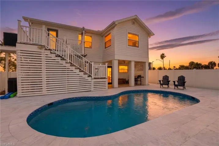 Rear view of property featuring stairs, a patio area, and a fenced backyard Virtually Edited