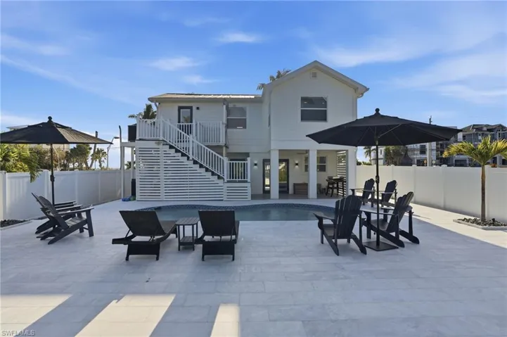 Rear view of property with stairway, a patio, a fenced backyard, a balcony, and outdoor dining area Virtually Edited