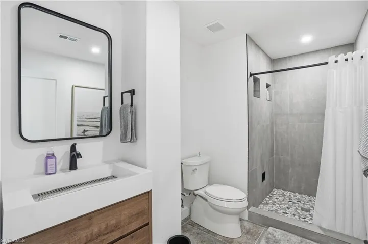 Full bathroom featuring a stall shower, vanity, and recessed lighting Virtually Edited