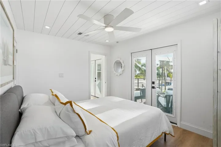 Bedroom featuring wood finished floors, access to exterior, french doors, recessed lighting, and ceiling fan Virtually Edited