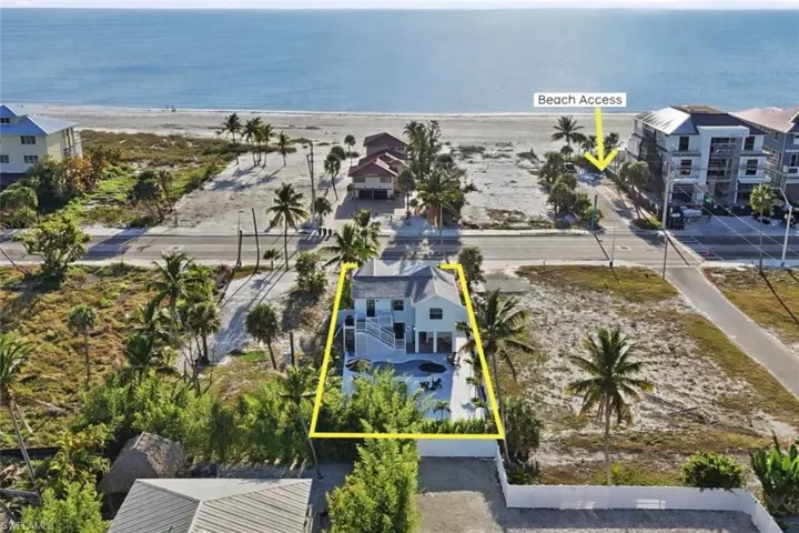 Aerial perspective of suburban area featuring property parcel outlined and a nearby body of water virtually edited