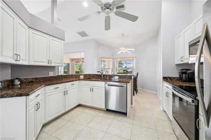 Kitchen with stainless steel appliances, white cabinetry, a peninsula, and healthy amount of natural light