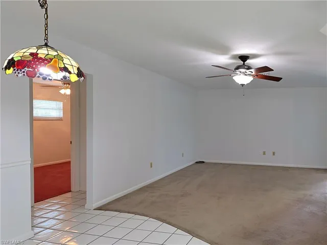 Spacious room featuring neutral carpeting and white walls