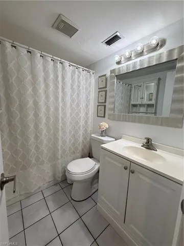 Bathroom with vanity, a shower with curtain, and light tile patterned floors