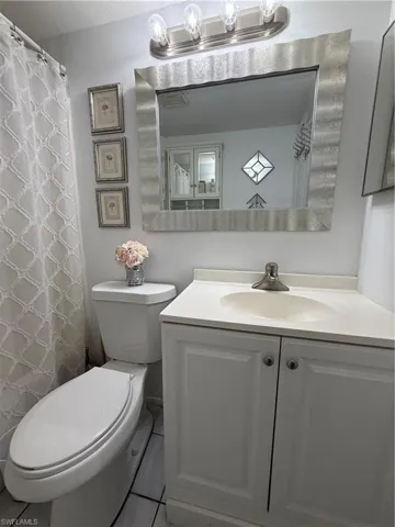 Bathroom with a shower with curtain, vanity, and light tile patterned floors