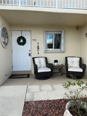 Property entrance featuring stucco siding and a patio