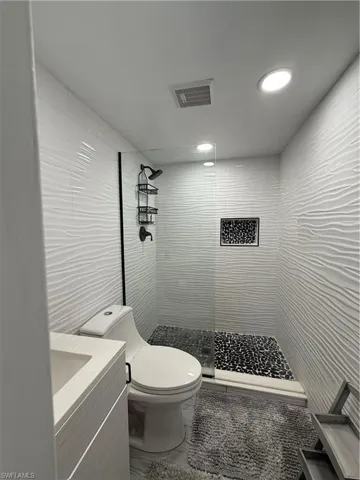 Full bath with vanity, a stall shower, and recessed lighting