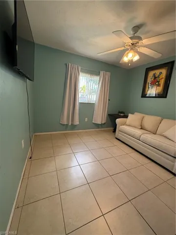 Living room featuring ceiling fan and light tile patterned floors