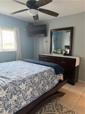 Bedroom with light tile patterned flooring and ceiling fan