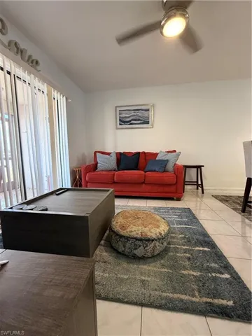 Living area featuring ceiling fan and baseboards