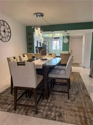 Dining space with light tile patterned flooring and baseboards