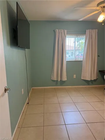 Unfurnished bedroom featuring ceiling fan and light tile patterned flooring
