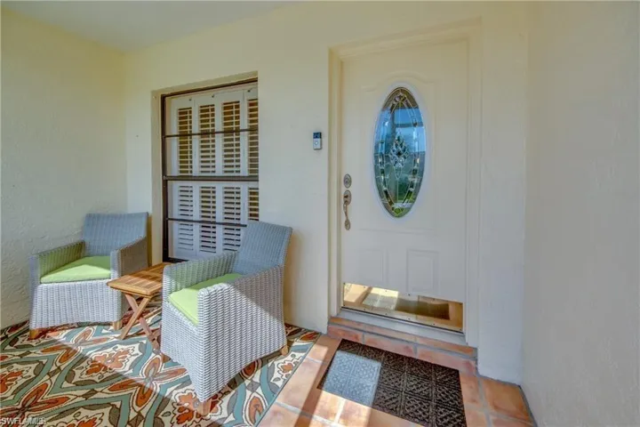 TILED FRONT ENTRY WITH LEADED GLASS FRONT DOOR.