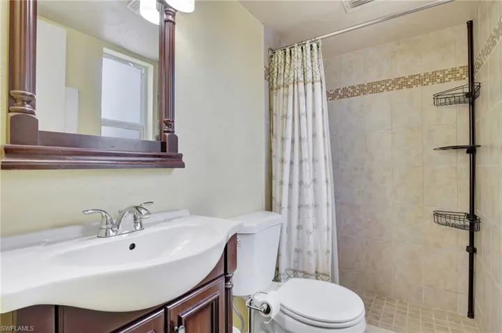 Bathroom with vanity, a shower with curtain, and toilet