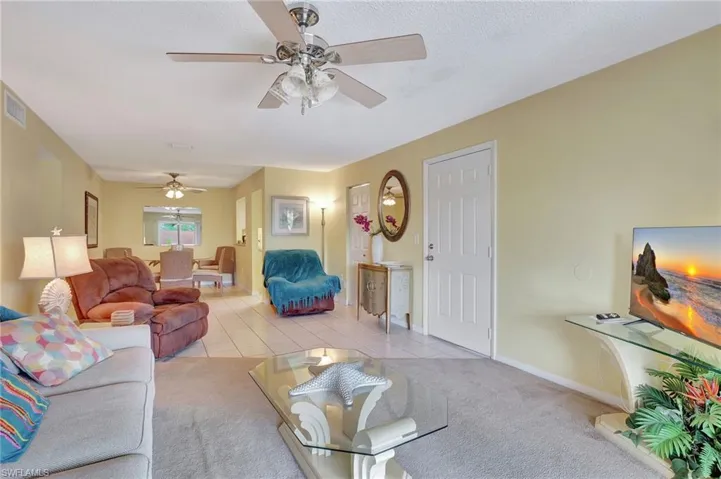 Carpeted living room with ceiling fan