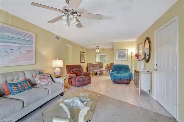 Living room with ceiling fan and light colored carpet