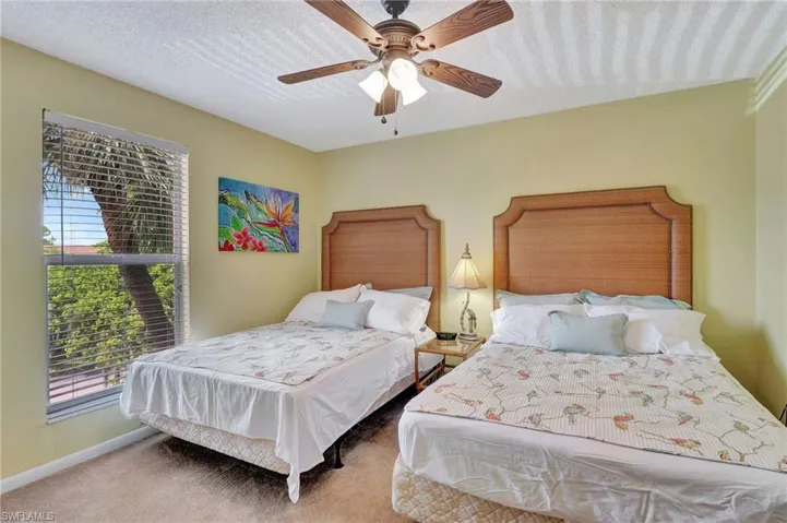 Carpeted bedroom with a textured ceiling and ceiling fan