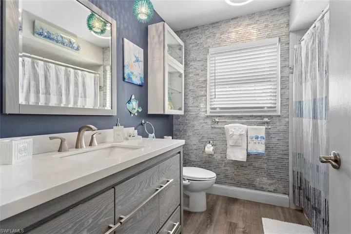 Guest bathroom with tiled wall, beautiful trim and luxury vanity!