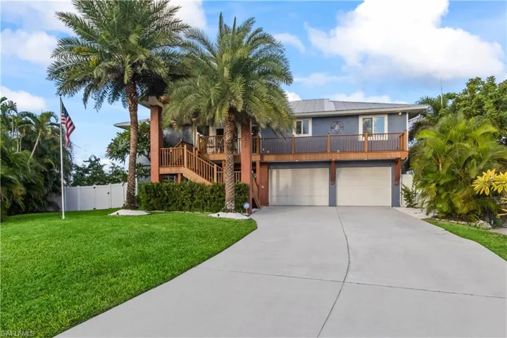 Welcome Home to Paradise! This inviting coastal residence blends classic Florida charm with modern luxury.  Tons of parking - both in the garage and additional extended driveway!  Mature royal palms flank the entry and ithe curb appeal is off the charts! Fenced for privacy as well!