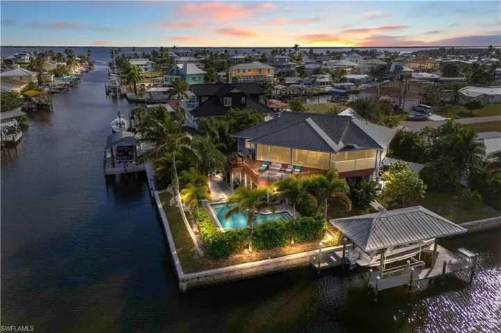 Boater’s Dream Location! Two minutes to open water with direct Gulf access—ideal for fishing trips, island hopping, and sunset cruises.  Covered boathouse, resort style backyard!