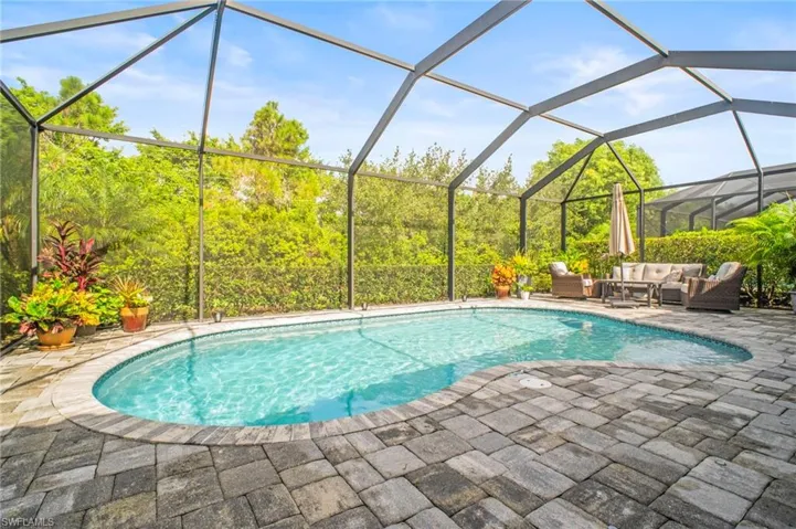 Swimming pool featuring a sunroom, glass enclosure, a patio area, and an outdoor lounge area