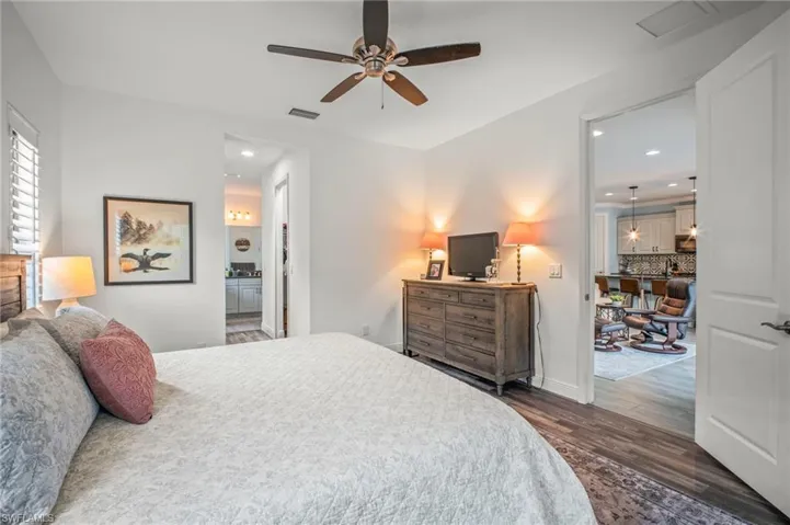 Bedroom featuring recessed lighting, a ceiling fan, ensuite bathroom, and dark wood finished floors