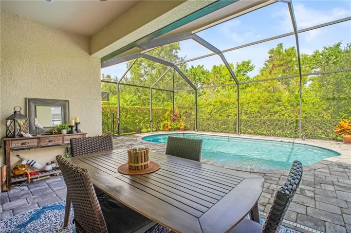 Outdoor pool with a lanai, a sunroom, a patio, and outdoor dining area
