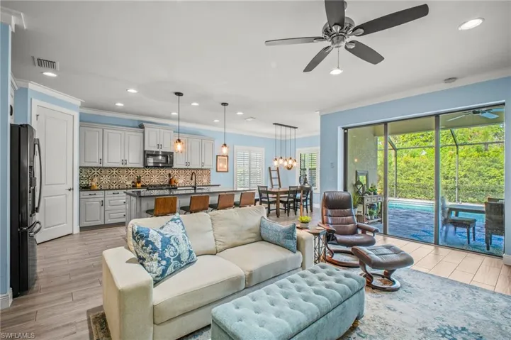 Living area featuring crown molding, recessed lighting, ceiling fan, light wood finished floors, and a sunroom