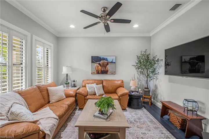 Living area with ornamental molding, a ceiling fan, recessed lighting, and wood finished floors