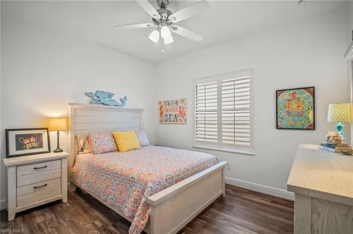 Bedroom with dark wood-style flooring and a ceiling fan